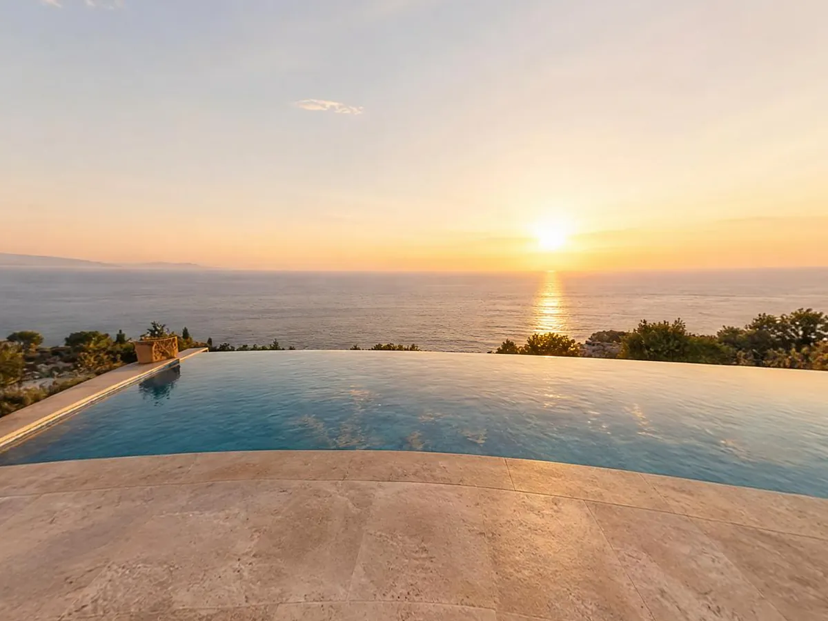 Infinity pool terrace overlooking the sea at sunset