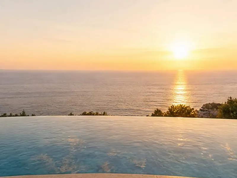 A regular phone-style photo of an infinity pool at sunset